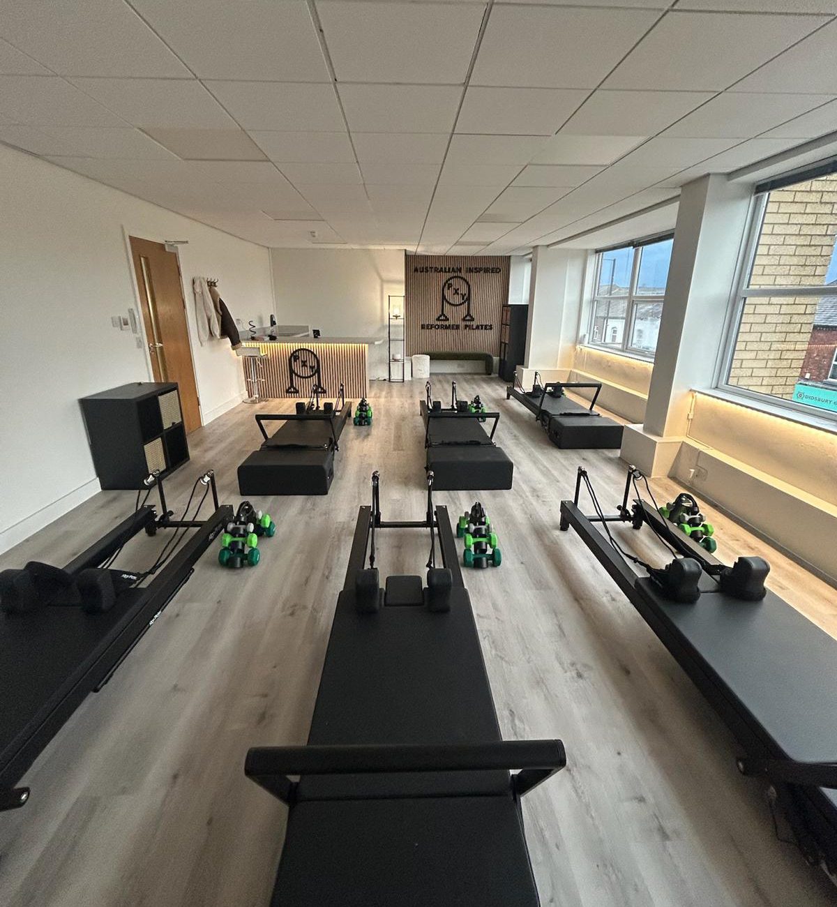 Reformer beds lined up inside the PXY Reformer Pilates studio in Didsbury