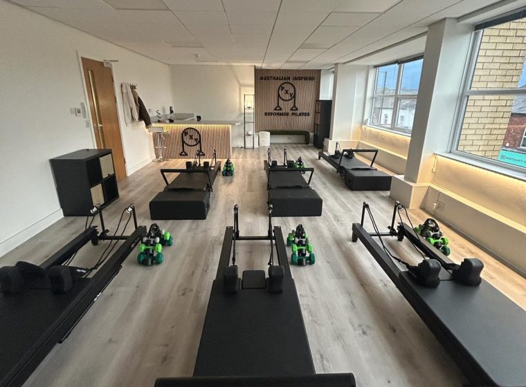 Reformer beds lined up inside the PXY Reformer Pilates studio in Didsbury