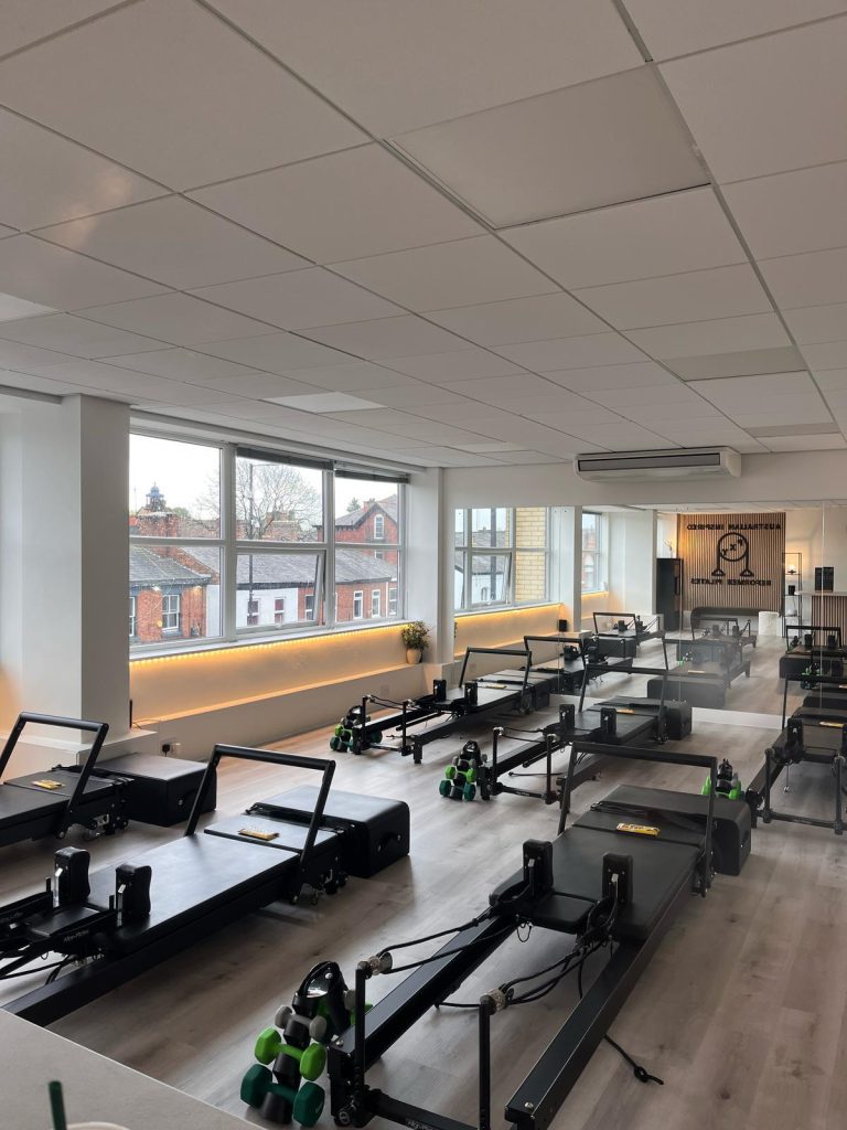 Sunlight streaming into the PXY Reformer Pilates studio with views over Didsbury rooftops