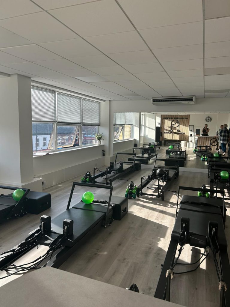 Reformer beds set up with balls and hand weights at PXY Reformer Pilates