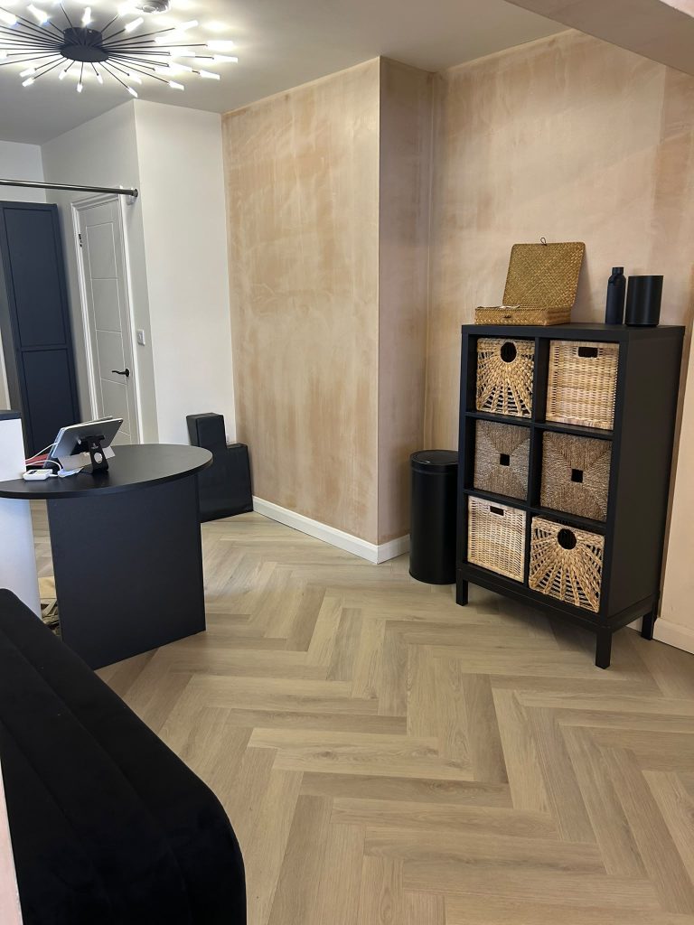 The reception area at PXY Chorlton, with herringbone floors, warm plaster walls and woven storage baskets
