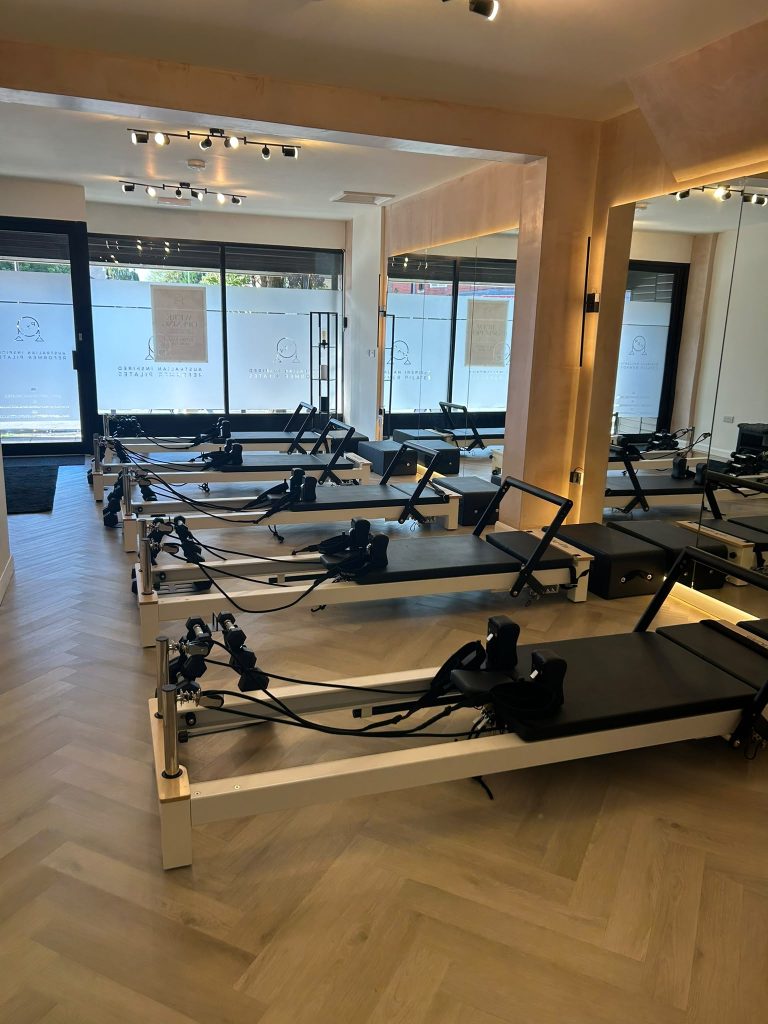 Reformer beds lined up facing the frosted front windows of the Chorlton studio